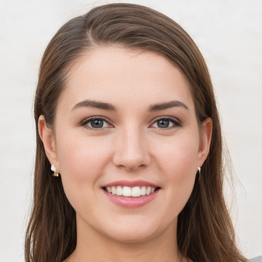 Joyful white young-adult female with long  brown hair and grey eyes