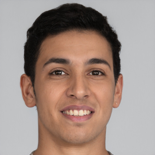 Joyful latino young-adult male with short  brown hair and brown eyes