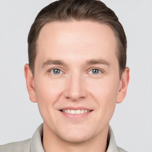 Joyful white young-adult male with short  brown hair and grey eyes