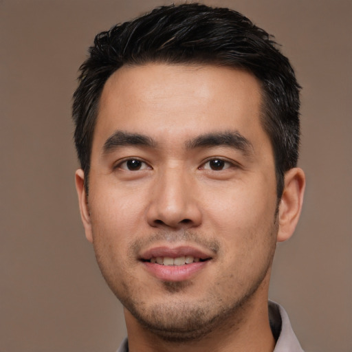Joyful asian young-adult male with short  black hair and brown eyes