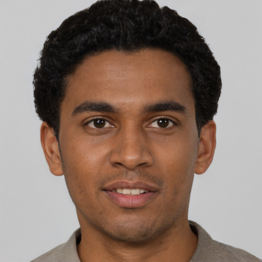 Joyful black young-adult male with short  black hair and brown eyes