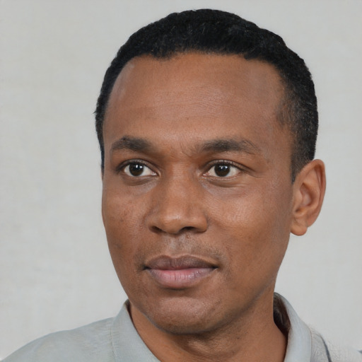 Joyful black young-adult male with short  black hair and brown eyes