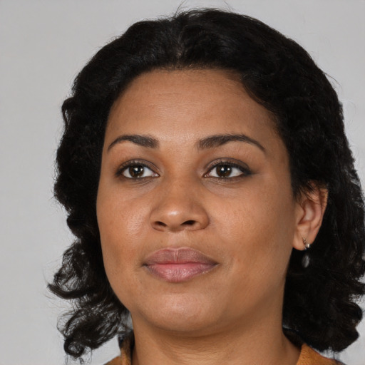 Joyful latino adult female with medium  brown hair and brown eyes