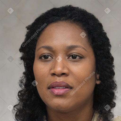 Joyful black young-adult female with long  black hair and brown eyes