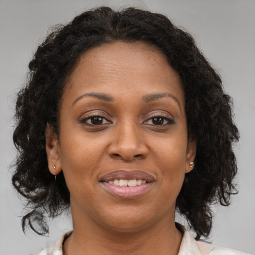 Joyful black adult female with medium  brown hair and brown eyes