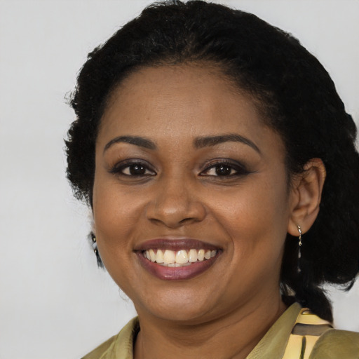 Joyful black young-adult female with long  black hair and brown eyes