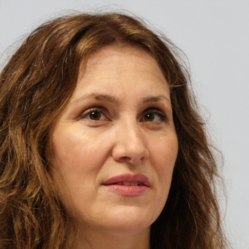 Joyful white adult female with long  brown hair and brown eyes