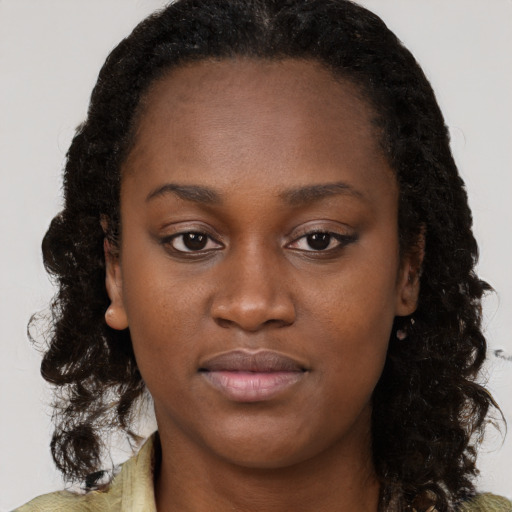 Joyful black young-adult female with long  brown hair and brown eyes