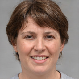 Joyful white adult female with medium  brown hair and grey eyes