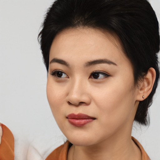 Joyful asian young-adult female with short  brown hair and brown eyes