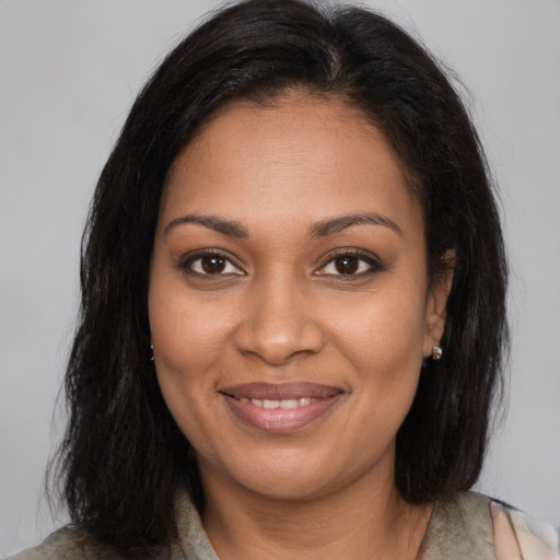 Joyful black young-adult female with long  brown hair and brown eyes