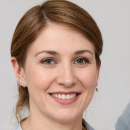 Joyful white young-adult female with medium  brown hair and grey eyes