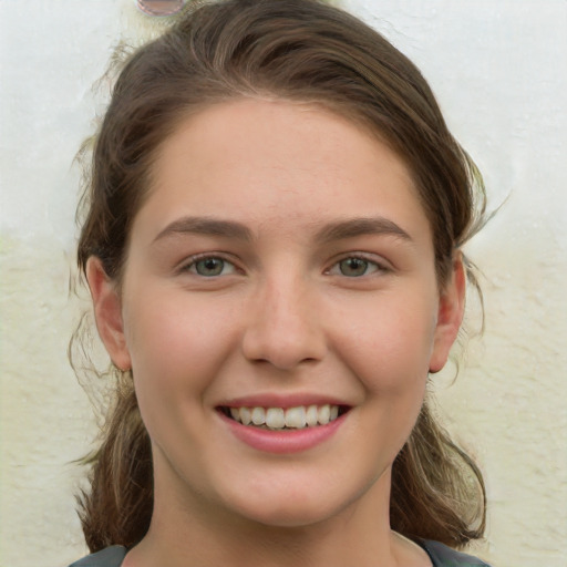 Joyful white young-adult female with medium  brown hair and green eyes