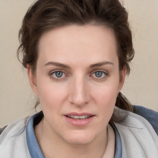 Joyful white young-adult female with short  brown hair and blue eyes