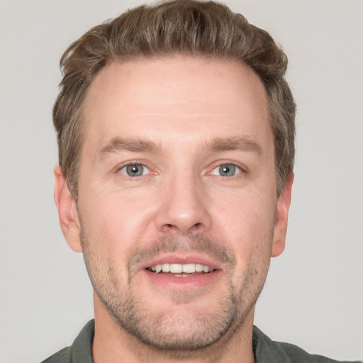 Joyful white adult male with short  brown hair and grey eyes