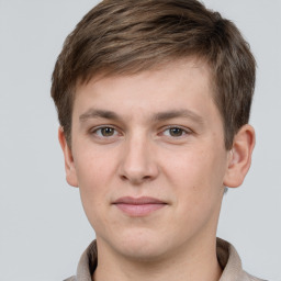 Joyful white young-adult male with short  brown hair and grey eyes