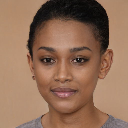 Joyful black young-adult female with short  black hair and brown eyes