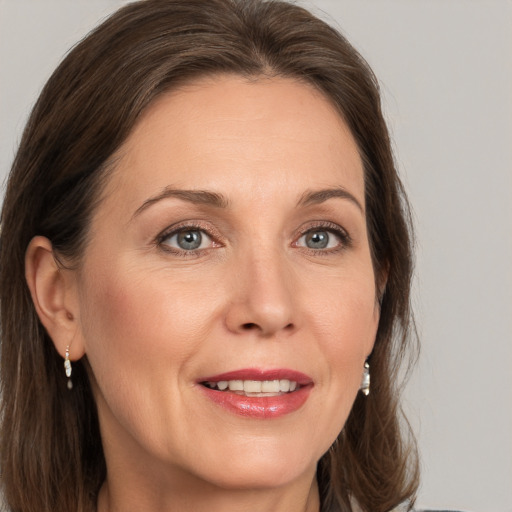 Joyful white adult female with medium  brown hair and grey eyes