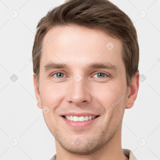 Joyful white young-adult male with short  brown hair and grey eyes