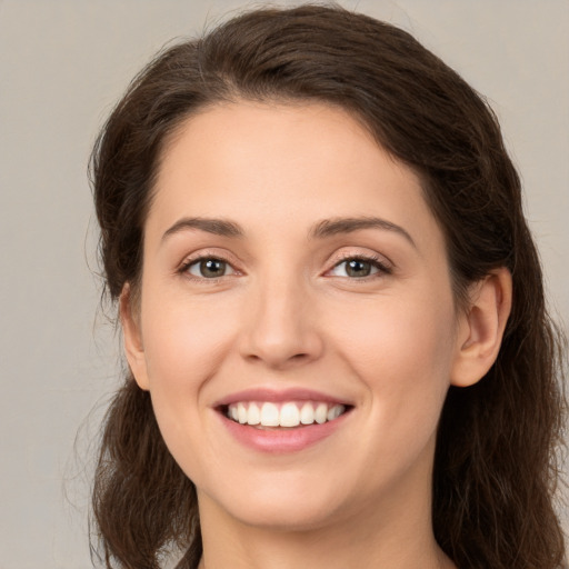 Joyful white young-adult female with long  brown hair and brown eyes