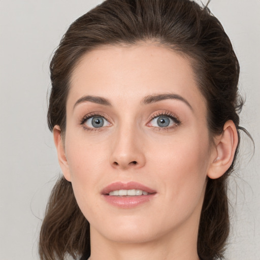 Joyful white young-adult female with medium  brown hair and grey eyes