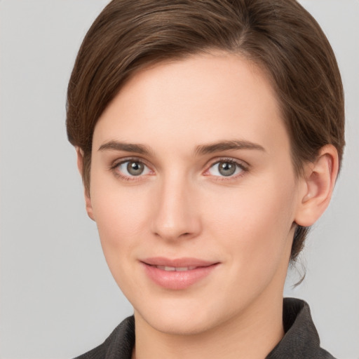 Joyful white young-adult female with short  brown hair and grey eyes