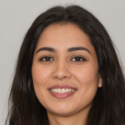 Joyful latino young-adult female with long  brown hair and brown eyes