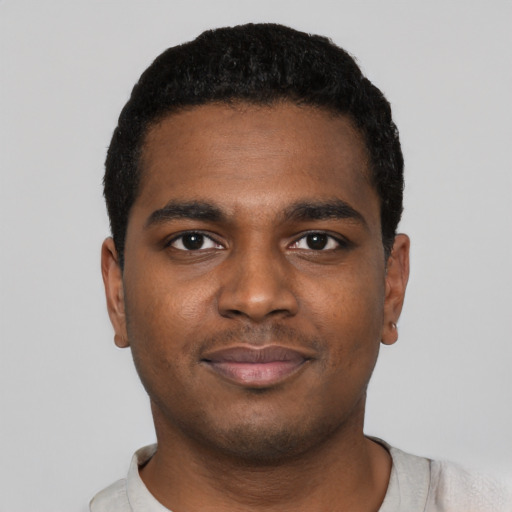 Joyful black young-adult male with short  black hair and brown eyes