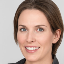 Joyful white adult female with medium  brown hair and grey eyes