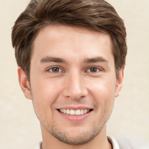 Joyful white young-adult male with short  brown hair and grey eyes