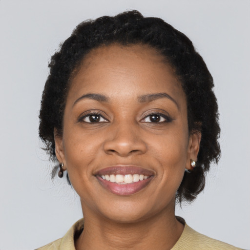 Joyful black young-adult female with short  black hair and brown eyes