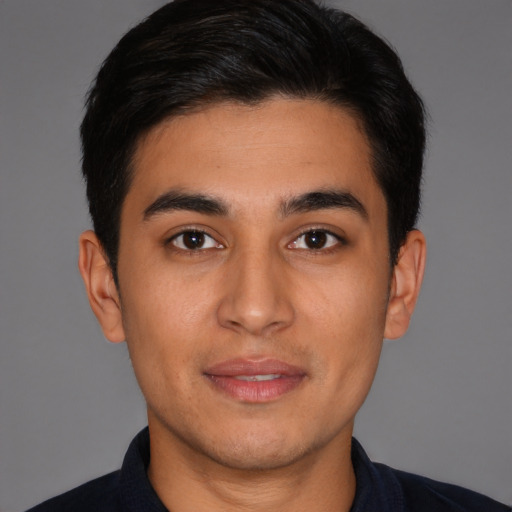 Joyful latino young-adult male with short  brown hair and brown eyes