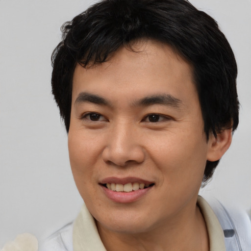 Joyful asian young-adult male with short  brown hair and brown eyes