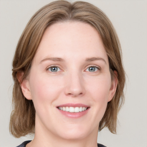 Joyful white young-adult female with medium  brown hair and blue eyes