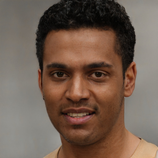 Joyful black young-adult male with short  black hair and brown eyes