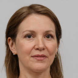 Joyful white adult female with long  brown hair and grey eyes