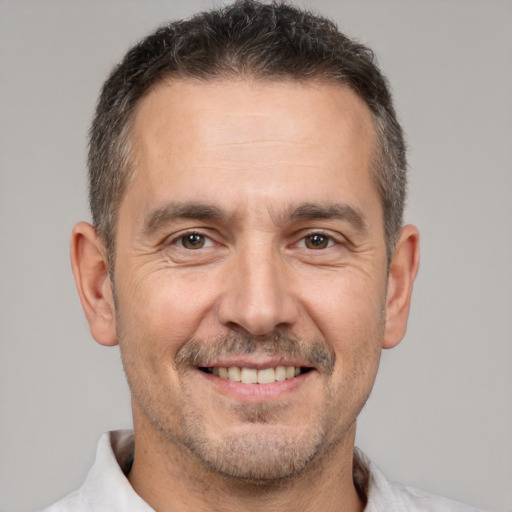 Joyful white adult male with short  brown hair and brown eyes