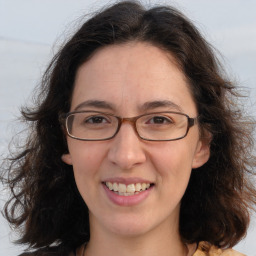 Joyful white adult female with long  brown hair and brown eyes