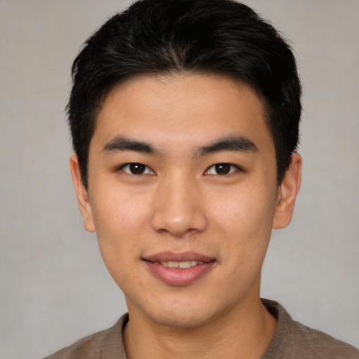 Joyful asian young-adult male with short  brown hair and brown eyes