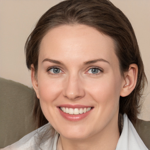 Joyful white young-adult female with medium  brown hair and grey eyes