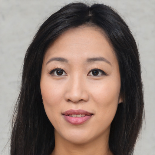 Joyful asian young-adult female with long  brown hair and brown eyes