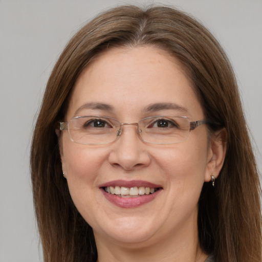 Joyful white adult female with long  brown hair and grey eyes