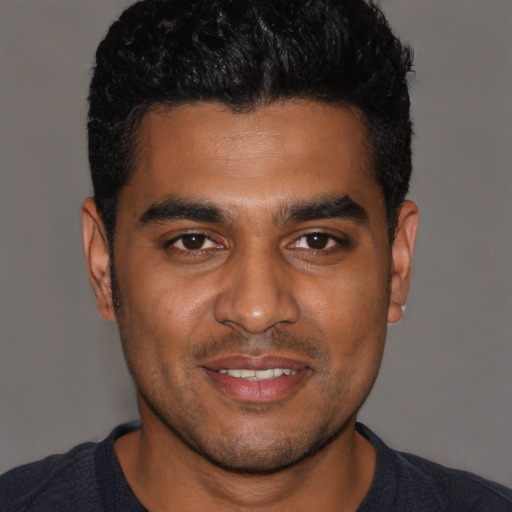 Joyful black young-adult male with short  black hair and brown eyes