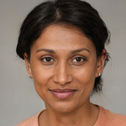 Joyful black adult female with medium  brown hair and brown eyes