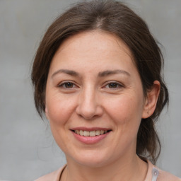 Joyful white adult female with medium  brown hair and brown eyes