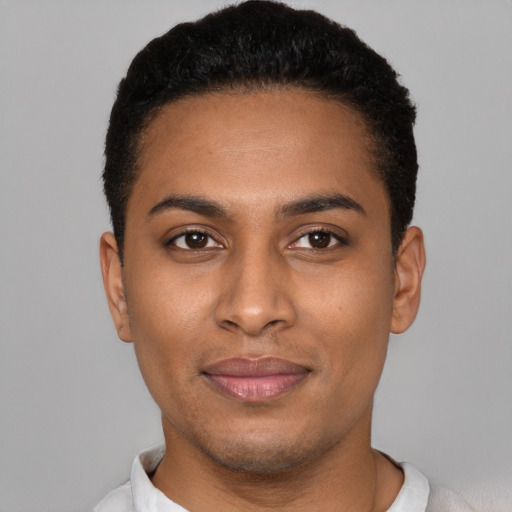 Joyful black young-adult male with short  black hair and brown eyes