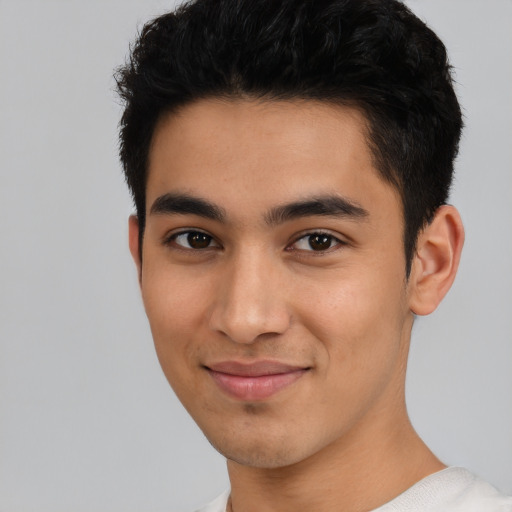 Joyful latino young-adult male with short  black hair and brown eyes