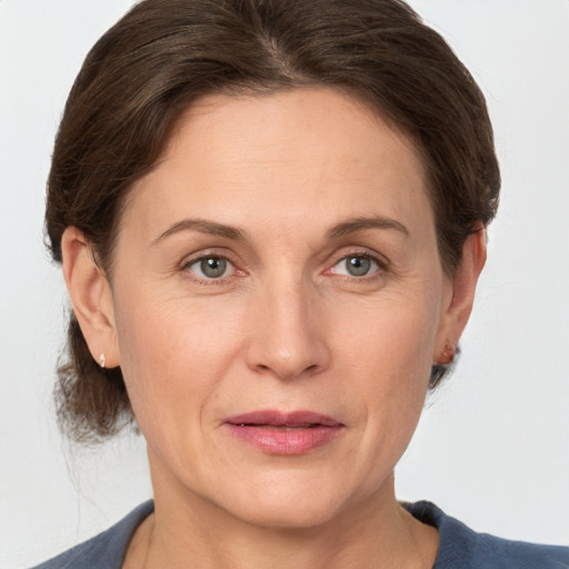 Joyful white adult female with medium  brown hair and grey eyes