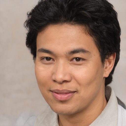 Joyful asian adult male with short  brown hair and brown eyes