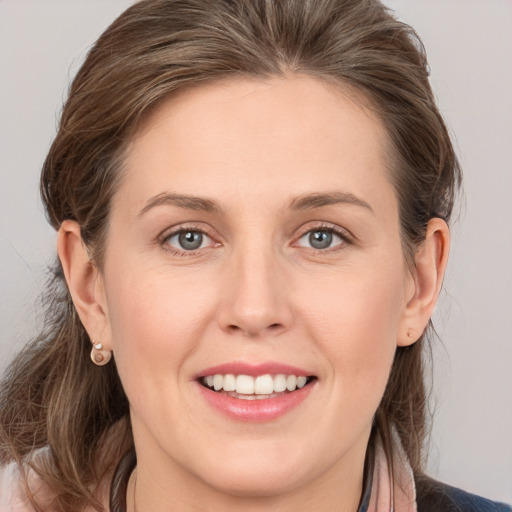 Joyful white young-adult female with medium  brown hair and grey eyes